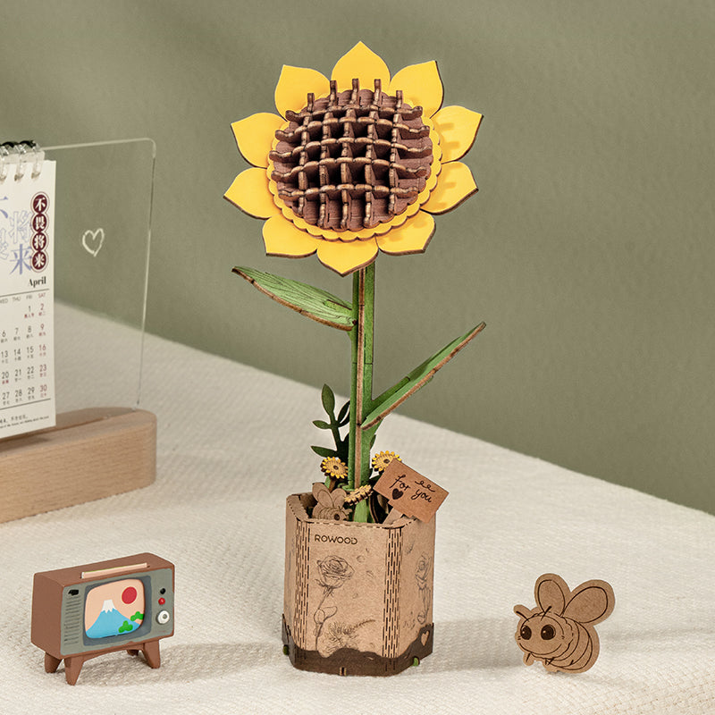 Rowood wooden sunflower stands in a paper bag style planter with small desk decorations.