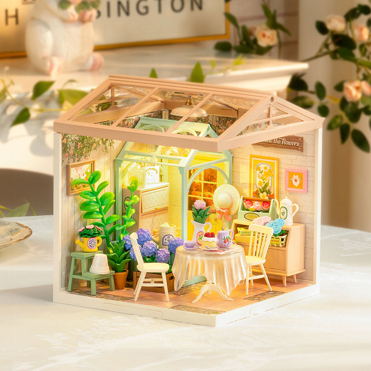 Rolife Blooming Tea Garden miniature greenhouse displayed on a sunlit tabletop with plants