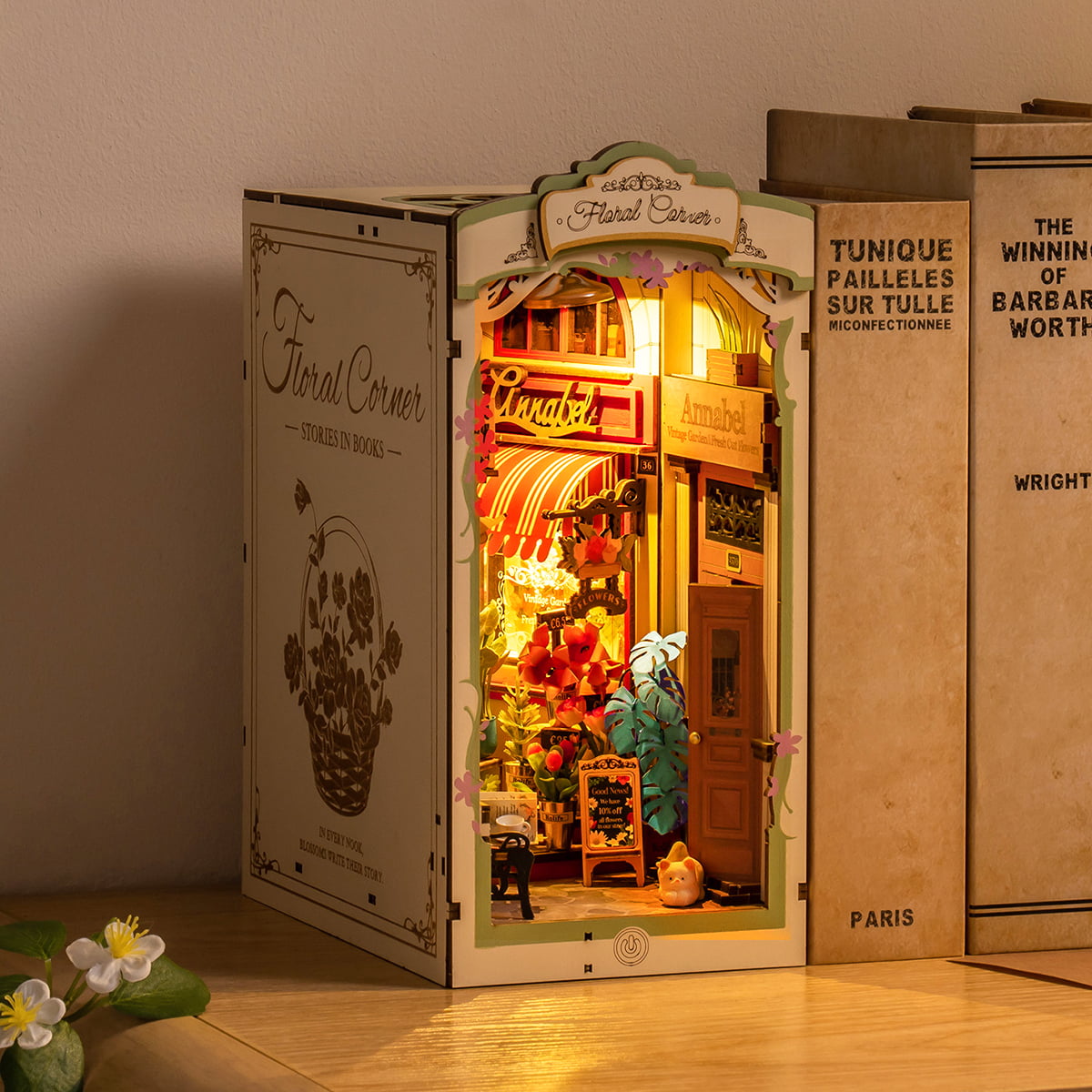 Rolife Floral Corner DIY book nook with illuminated flower shop on bookshelf beside French novels
