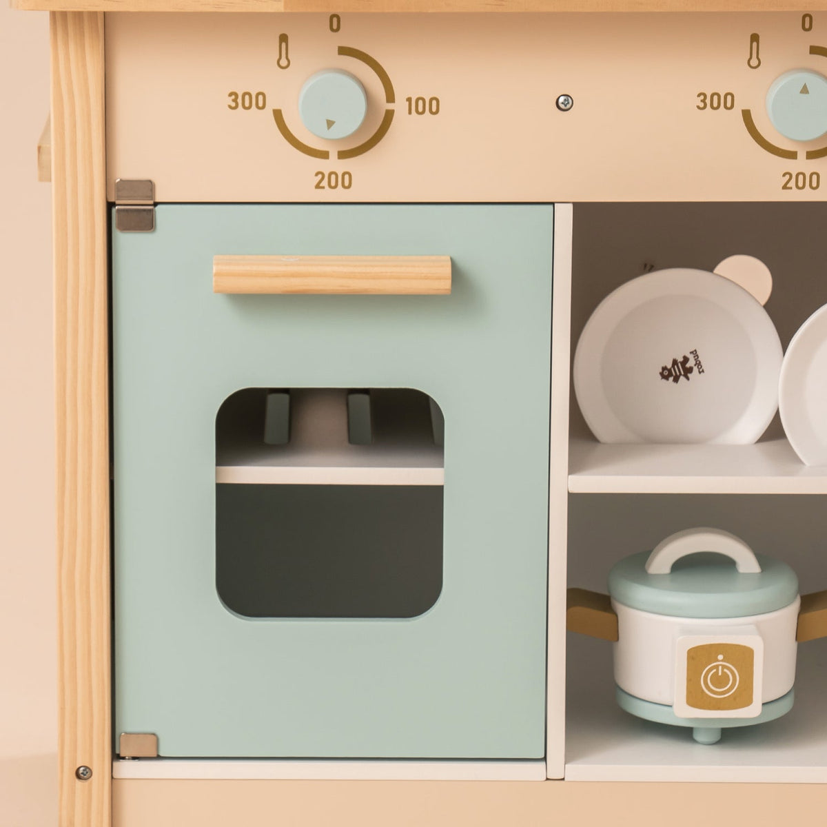 ROBUD kitchen lower section with dark green oven door, adjacent open shelf holding white plates and a small mint rice cooker