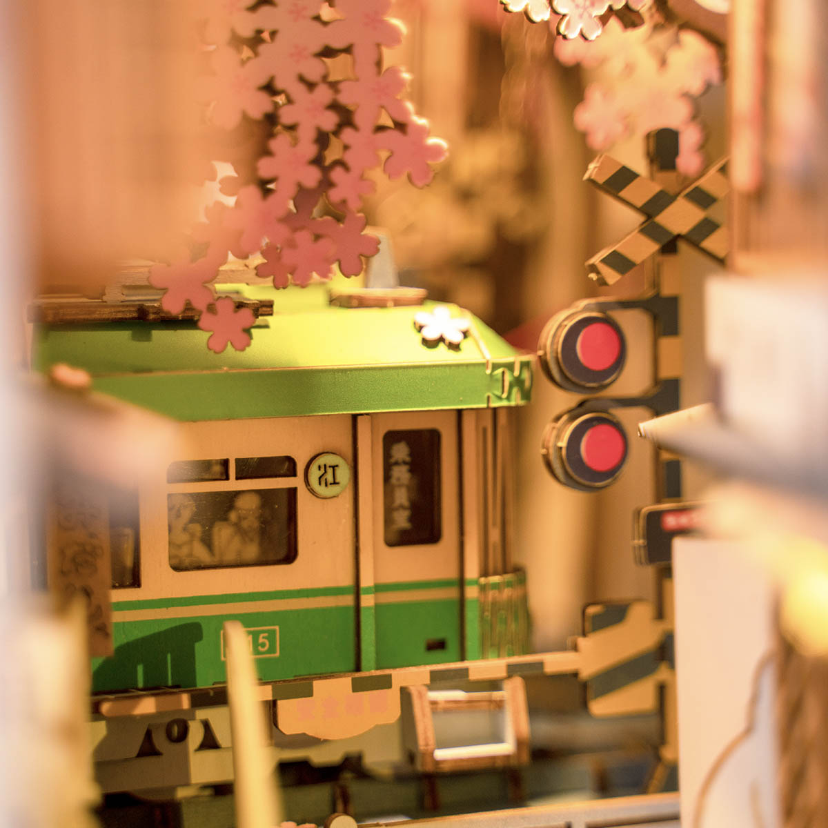 Rolife Sakura Densya TGB01 interior close-up showing green tram car with red signal and cherry blossom canopy